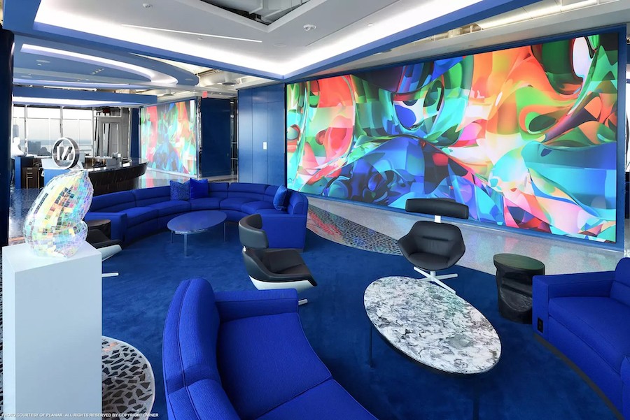 Extra-large video wall display in modern office showing digital NFT artwork